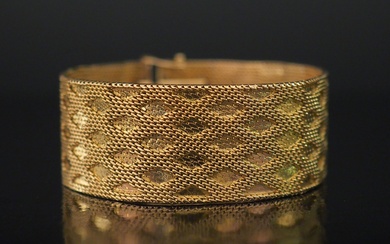 Bracelet manchette souple en or jaune, maille plate, à décor de losanges. Long. 18,3 cm...