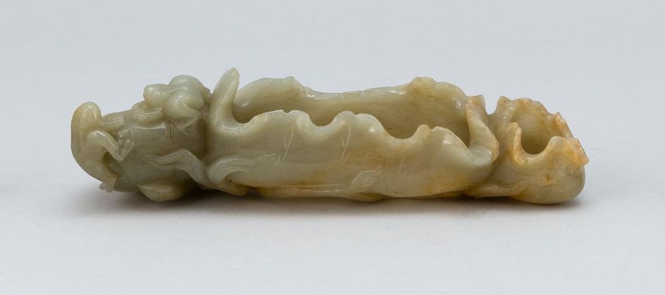 CHINESE CARVED CELADON GREEN/GRAY JADE WRITER'S COUPE In the form of two furled lotus leaves and a lotus pod with two frogs, on a ba..
