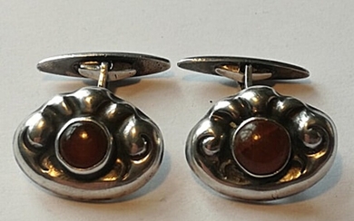 Hans Hansen: A pair of amber cufflinks each set with a cabochon amber, mounted in silver. 2.1×1.6 cm. (2)