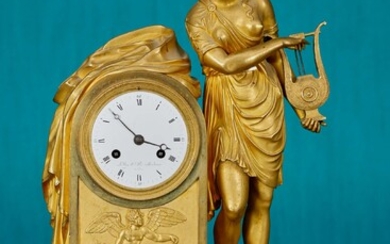 Pendule borne En bronze doré et ciselé à décor d’une femme vêtue à l’antique jouant...