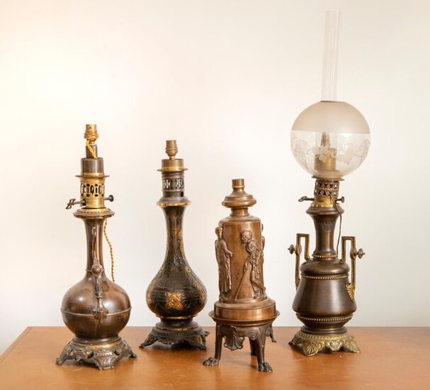 SUITE de QUATRE LAMPES à pétrole en bronze comprenant :...