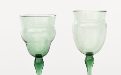 Two James Powell & Sons Whitefriars emerald green wine glasses designed by T G Jackson, each with swollen stems and swollen glass bowls, unsigned, 13cm. high (tallest), (2) Literature Lesley Jackson Whitefriars Glass the Art of James Powell & Sons...