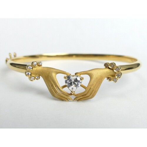 18ct gold hands holding a heart design stone set hinged bang...
