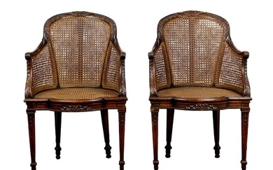 A pair of Louis XV style caned walnut bergeres