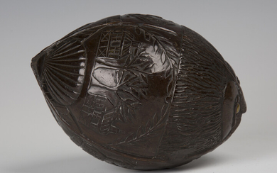 A 19th century carved coconut bugbear powder flask, one end typically worked with a mask with inset