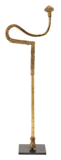 A Dervish crutch with gilding and inscription, North India, probably Punjab, 19th century, metal overlaid with gold, on metal stand, 52cm. long, shaft 1.2-1.6cm. wide Provenance: Private Collection France. Brought back to France by the vendor's...