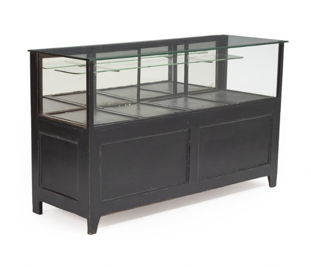 A French 20th century black painted wood counter, front, sides and top with thick glass. H. 91. L. 150. W. 54 cm.