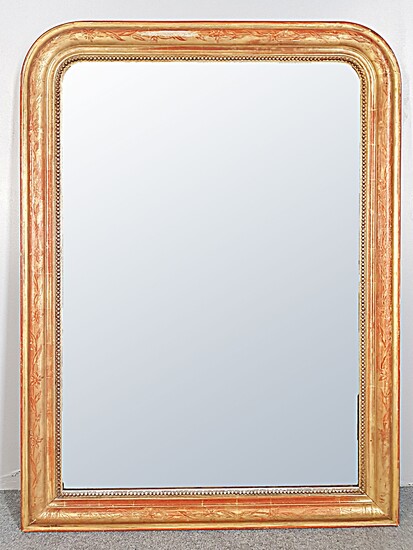 A Louis-Philippe style stucco and gilded wood mirror, decorated with...