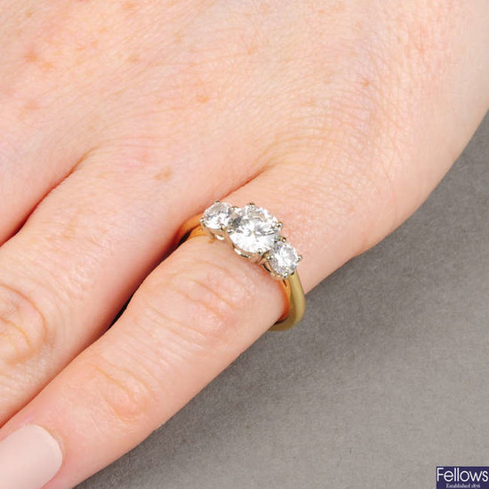 A brilliant-cut diamond three-stone ring. With reports