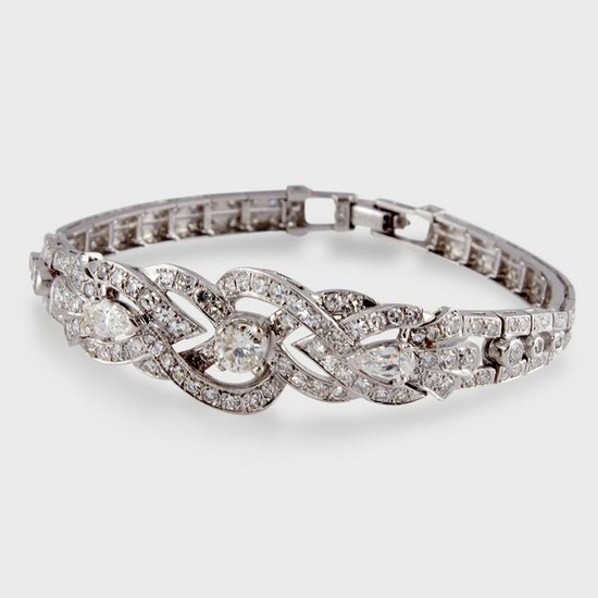 A diamond and fourteen karat white gold strap bracelet