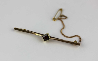 A gold and garnet single stone bar brooch