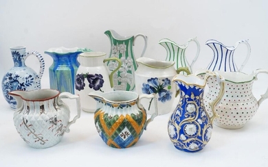 A group of eleven pottery jugs, late 19th-20th century, including: a Wemyss jug with flowers; a jug with blue stripes; a jug with green stripes; a Shelley jug with octagonal body; a Delft-style blue and white jug; a blue and parcel-gilt jug; a...