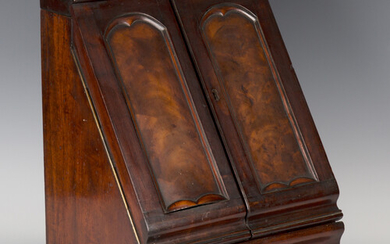 A mid-Victorian mahogany slope-fronted stationery box, the two arched panel doors enclosing a letter