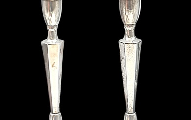 A pair of candlestick holders made of sterling silver...
