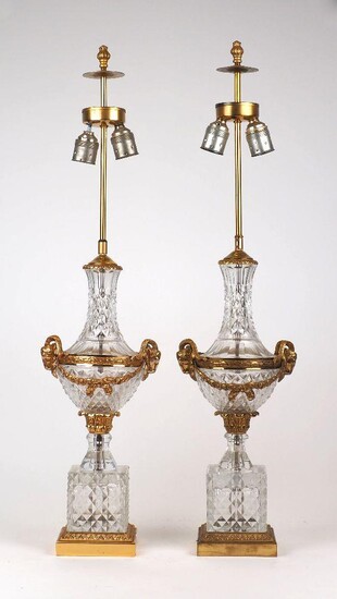 A pair of ormolu mounted cut baluster table lamps, purchased from Harrods as Baccarat, diamond pattern glass with head ornament, to a square plinth base, converted for electricity, each 83cm high (2) It is the buyer's responsibility to ensure that...