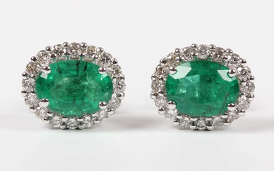 A pair of white gold, emerald and diamond oval cluster earstuds, each claw set with an oval cut emer