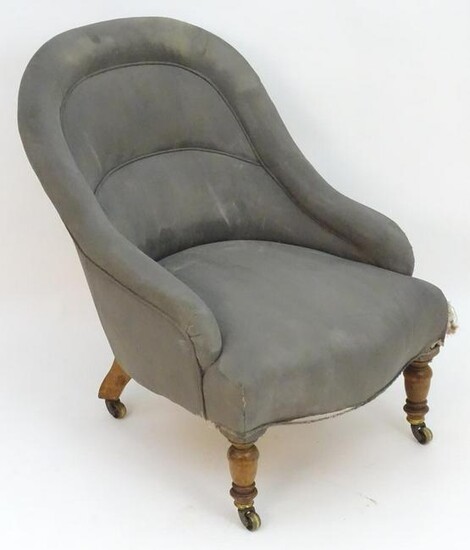 A small early 20thC upholstered tub armchair with