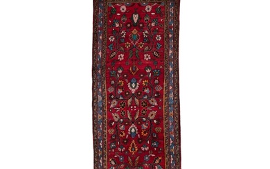 AN IRANIAN RED GROUND WOOL RUNNER, 275 x 105cm the central ...