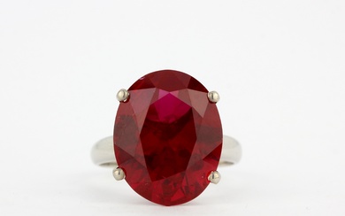 An 18ct white gold solitaire ring set with a large oval cut ruby (not natural), stone L. 1.8cm, (O.5).