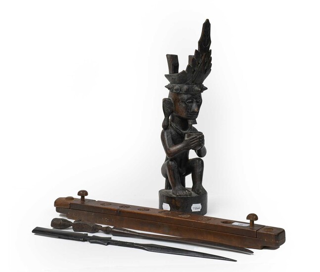 An African tribal carved hardwood statue of a seated...