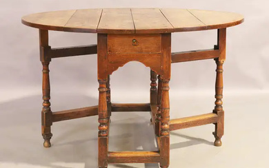 An English oak gate leg table, first quarter 18th Century, the oval...