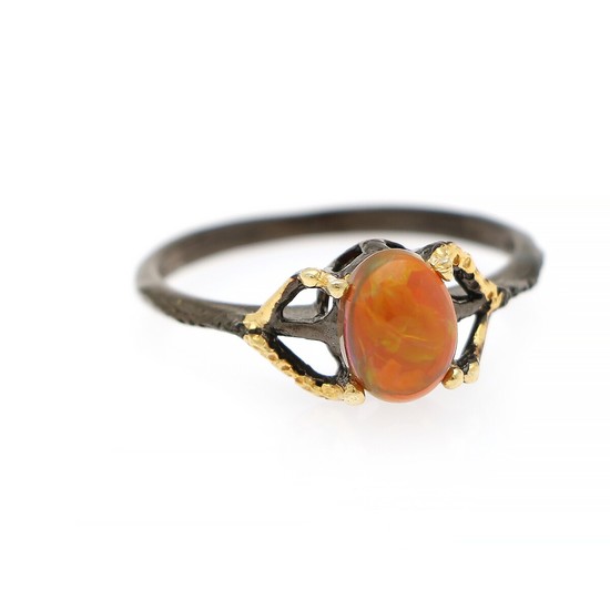 An opal ring set with an opal cabochon, mounted in black rhodium and gold plated sterling silver. Size 59.