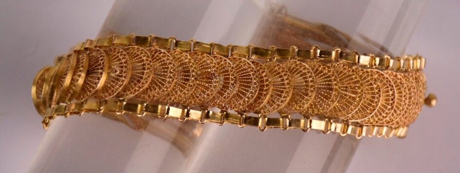 Bracelet articulée en or jaune à mailles ajourées filigranées. Poinçon...