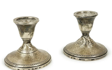 Coppia di candelieri in argento sterling, appesantiti, XX secolo, cm h 8, (difetti)