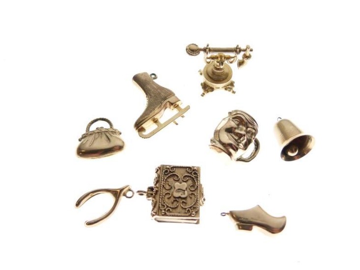 Eight assorted gold and yellow metal charms, 17g gross...