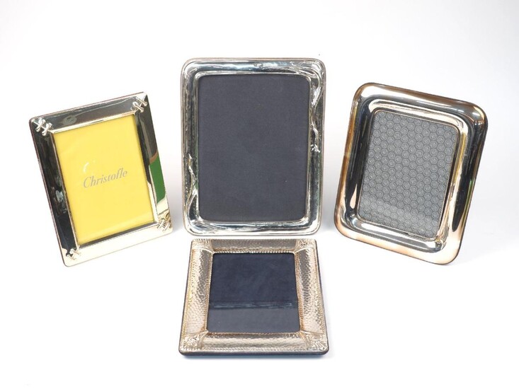 Four easel-back photo frames comprising: a Christofle silver plated example with stitch detail corners, 18 x 23cm; an Italian example with whiplash-style decoration, stamped 925, 21.8 x 27.8cm; and two further examples, one with hammered finish...
