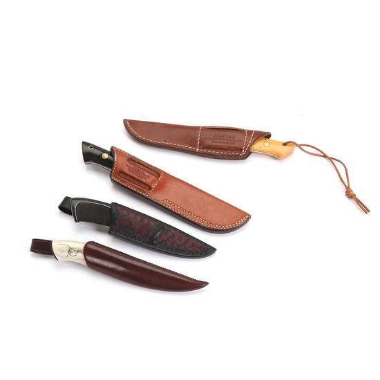 Four hunting knives in their sheats.