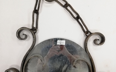 Important miroir à suspendre en fer forgé à décor de volutes. 66x50cm. Diam miroir :...