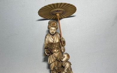 JAPON Okimono en ivoire sculpté représentant une femme à l'ombrelle aurpès de son fils portant...