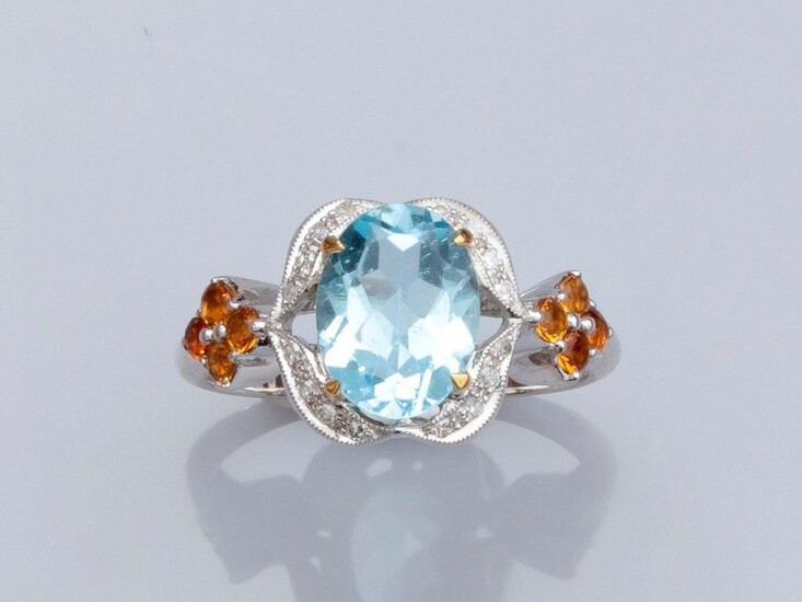 Ring in 375°/00 white gold, set with an oval blue topaz, shoulder set with small diamonds and citrines. 2.8 g. TDD 52. Width: 10.8 mm