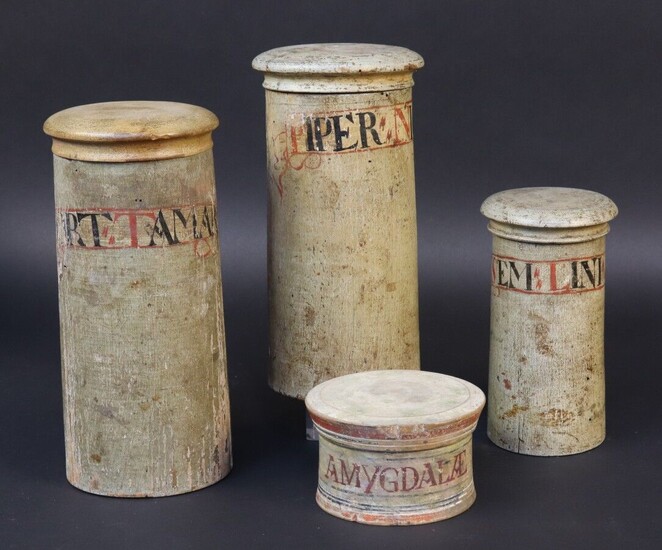 Series of three apothecary pots in turned wood. Straight shaft, interlocking lid (one lid replaced). Cartouche in painted lambel . Height 20,2 -19,5 and 14,2 cm. A model of pill box in turned wood with screw lid is joined. Cartouche in periphery...