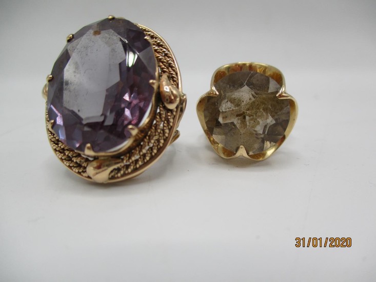 Two gold coloured metal rings, one set with a purple stone a...