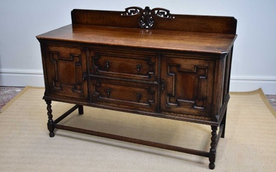 A 1920’s Jacobean Revival oak sideboard, with two drawers and...
