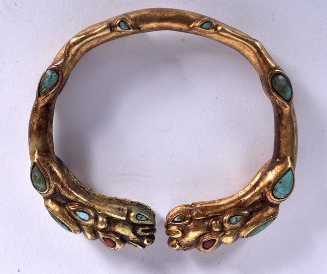 A CHINESE SINO TIBETAN YELLOW METAL BANGLE, formed with