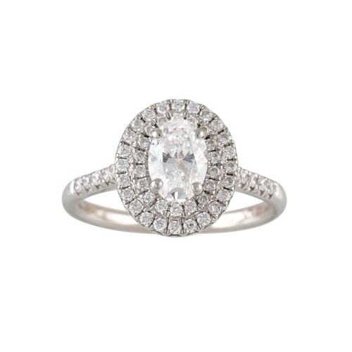 A DIAMOND CLUSTER RING, the oval diamond to diamond halo sur...