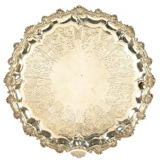 A GEORGE III SILVER SALVER on four volute capped feet,...