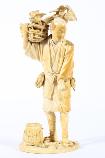 A Japanese ivory okimono, Meiji period, of a man holding a basket of vegetables