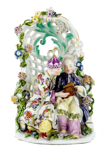 A Meissen porcelain chinoiserie group, c.1750-55, blue crossed swords mark, impressed | mark, modelled by P. Reinicke, with a couple seated before a pierced rococo arbour applied with meandering flowering branches, at discussion and holding a...