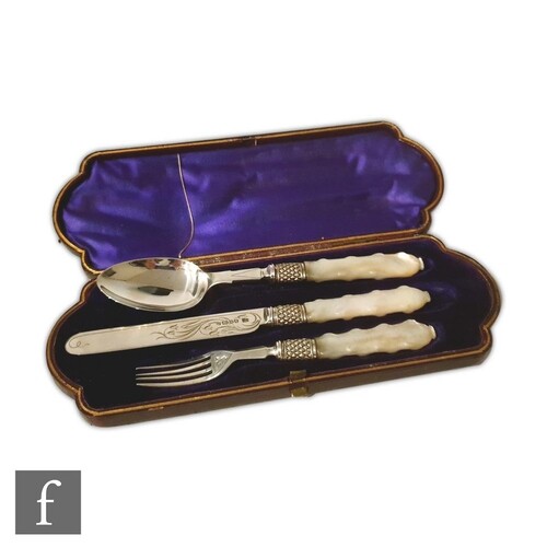 A cased hallmarked silver and mother of pearl knife, fork an...