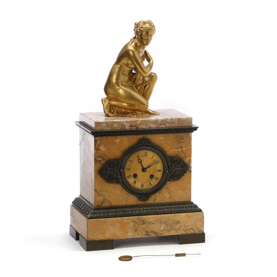 NOT SOLD. A late Empire figural table clock, gilt and patinated bronze with base of yellow Sienna marble. First half of the 19th century. H. 47 cm. W. 27 cm. D. 16 cm. – Bruun Rasmussen Auctioneers of Fine Art
