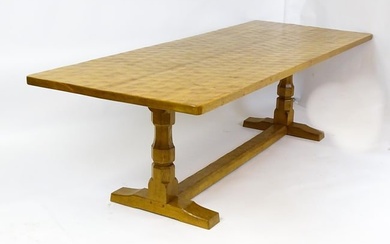 A mid 20thC Robert 'Mouseman' Thompson dining table. The 8ft long oak table top with an adzed finish