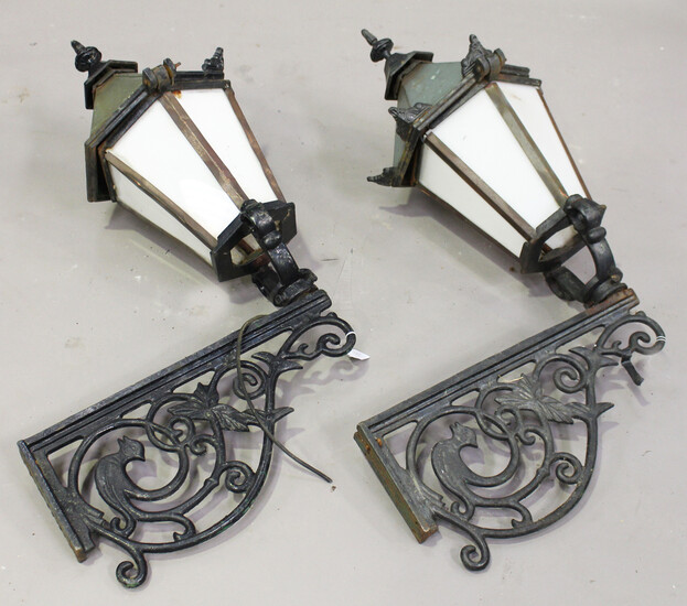 A pair of 20th century Continental cast iron wall mounted street lanterns with foliate scrolling sup