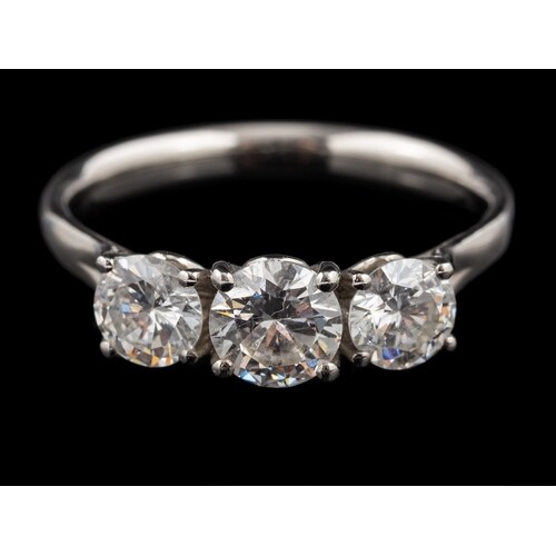 A platinum diamond three stone ring,: the central brilliant ...