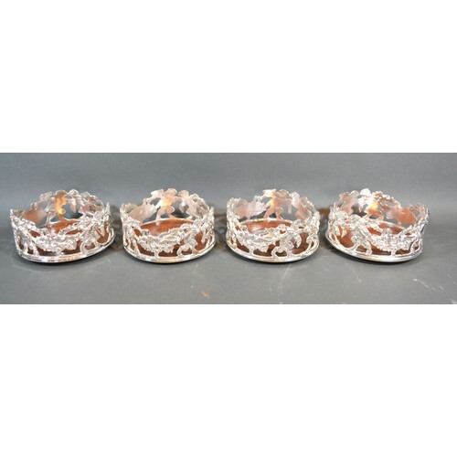 A set of four silver plated bottle coasters of pierced form ...