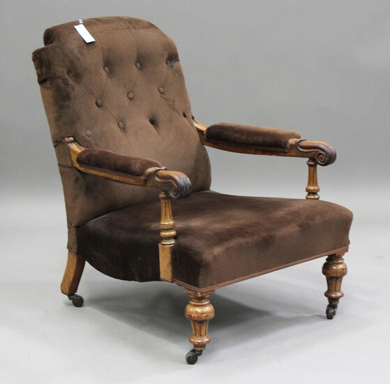 An early Victorian walnut framed gentleman's armchair with finely carved scroll handrests, upho