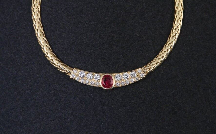 FLEXIBLE NECKLACE in 750-thousandths yellow gold, the chevron-decorated links holding in the centre a motif adorned with a cushion-set ruby between lines of round brilliant diamonds. Length. 44.5 cm. Gross weight: 38.1 g. Supple yellow gold necklace...